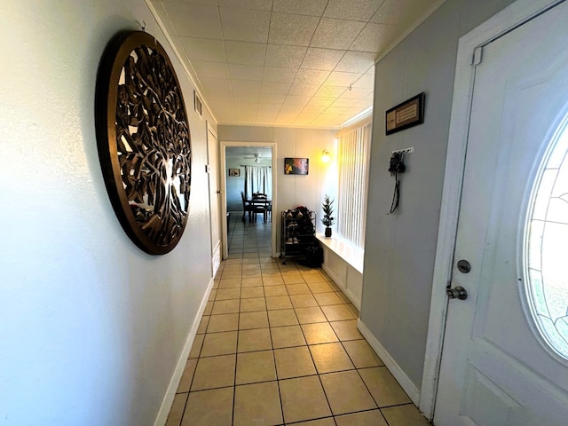 hall featuring light tile patterned floors and ornamental molding