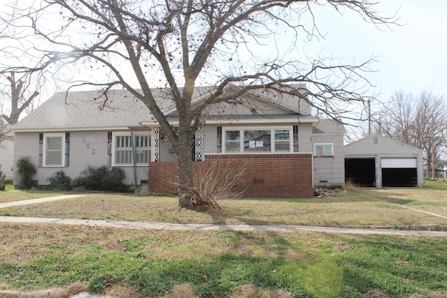 view of front of home with an outbuilding, a garage, and a front lawn