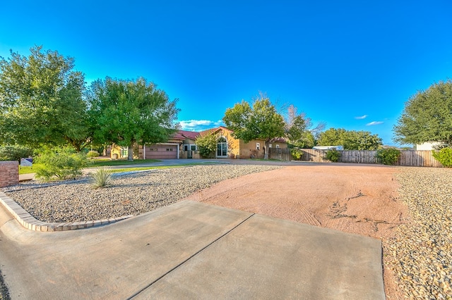 6026 Warwick Dr, San Angelo, TX 76901 - view of yard with curved driveway, fence, and a garage