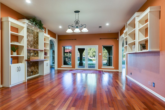 6026 Warwick Dr, San Angelo, TX 76901 - unfurnished living room with arched walkways, wood finished floors, recessed lighting, baseboards, and built in shelves