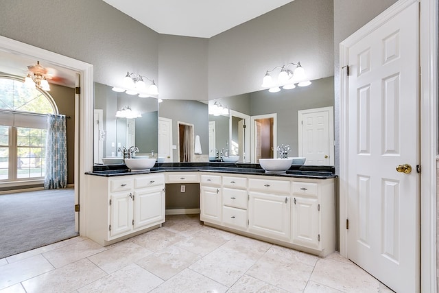6026 Warwick Dr, San Angelo, TX 76901 - bathroom with double vanity, tile patterned floors, and a towering ceiling