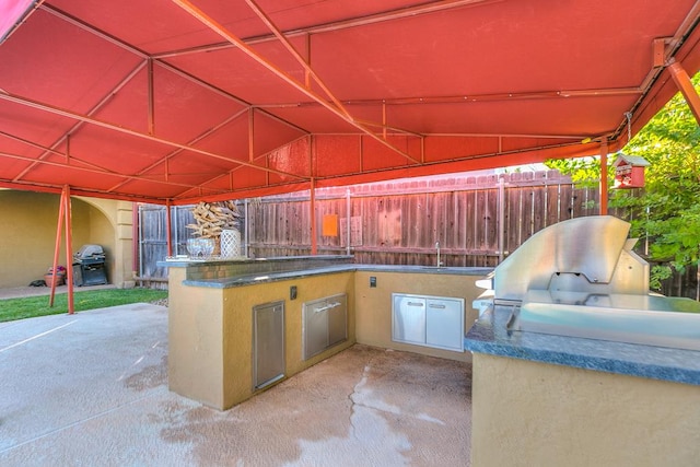 6026 Warwick Dr, San Angelo, TX 76901 - view of patio with exterior kitchen, fence, a grill, and a sink
