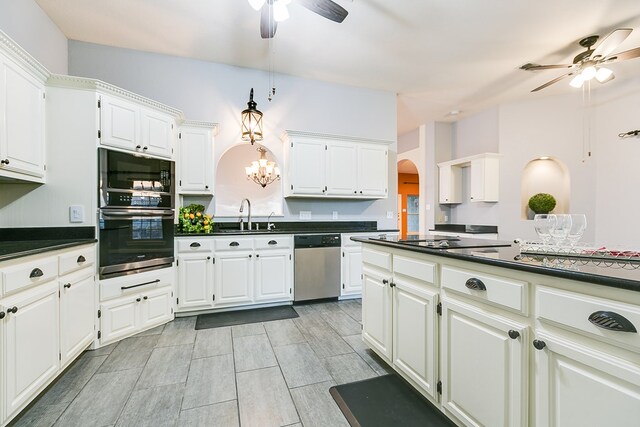 6026 Warwick Dr, San Angelo, TX 76901 - kitchen featuring stainless steel appliances, ceiling fan, a sink, dark countertops, and arched walkways