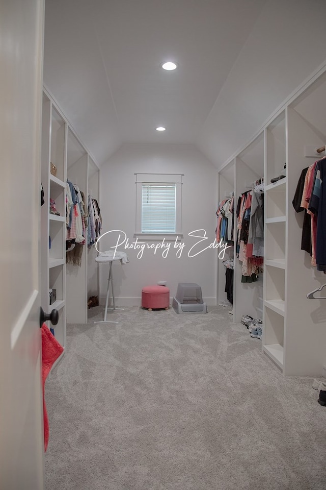 walk in closet featuring lofted ceiling and light carpet