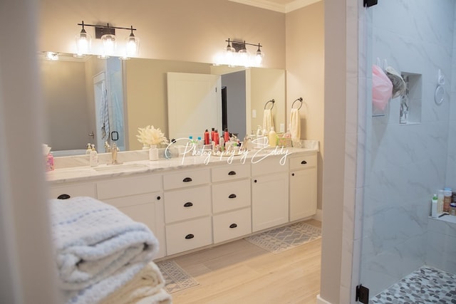 bathroom with vanity, crown molding, wood-type flooring, and walk in shower