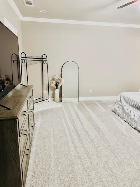 carpeted bedroom featuring crown molding and ceiling fan