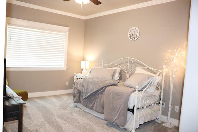 bedroom with crown molding, ceiling fan, and carpet flooring