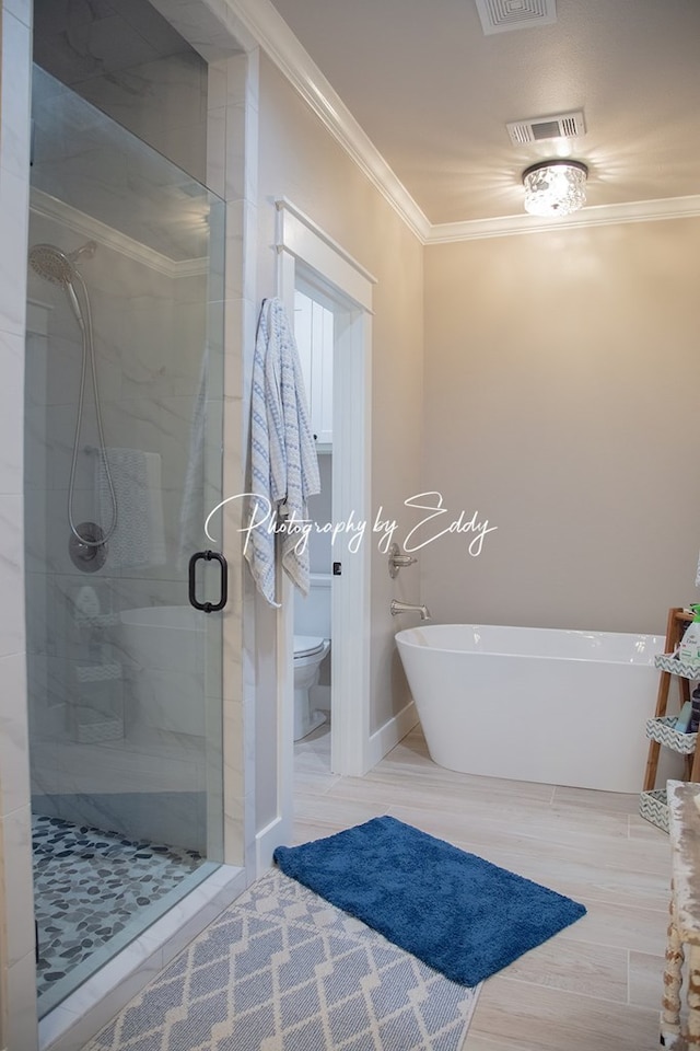 bathroom featuring ornamental molding, toilet, and separate shower and tub