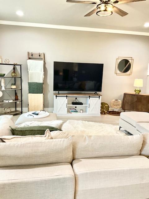 living room featuring crown molding, hardwood / wood-style flooring, and ceiling fan