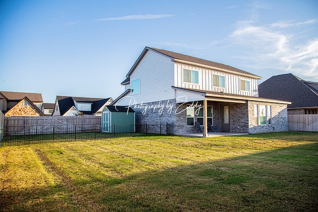 back of property with a storage unit, a patio area, and a lawn