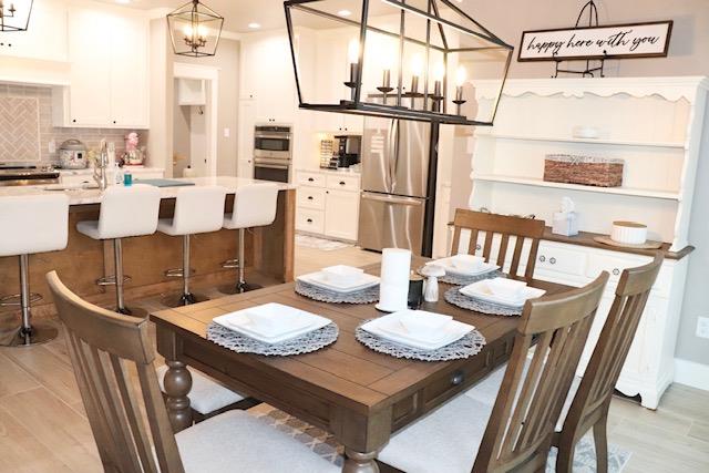 dining space with sink, a chandelier, and light hardwood / wood-style floors