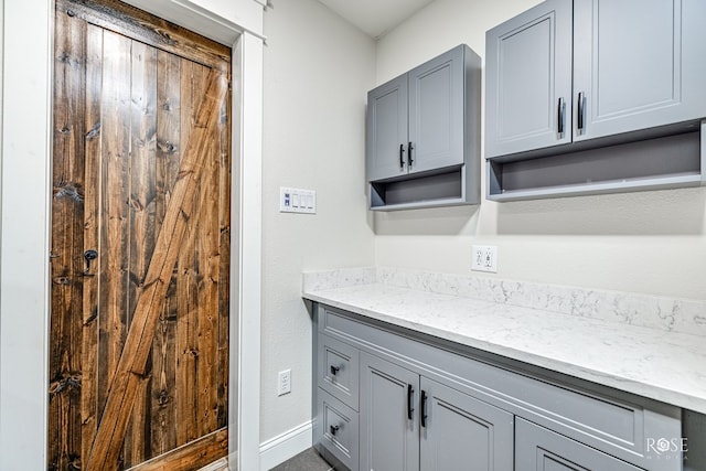 interior space featuring gray cabinets and light stone countertops