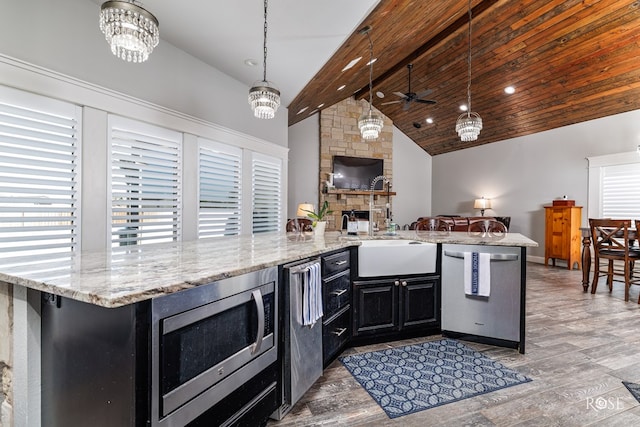 kitchen with sink, decorative light fixtures, stainless steel appliances, beam ceiling, and light hardwood / wood-style floors