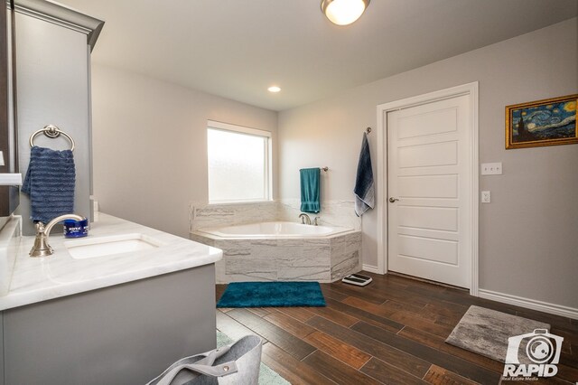 bathroom with vanity and tiled bath