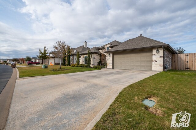 ranch-style home featuring a garage and a front lawn