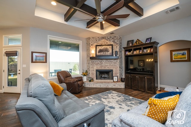 living room with plenty of natural light, dark wood-type flooring, and a fireplace