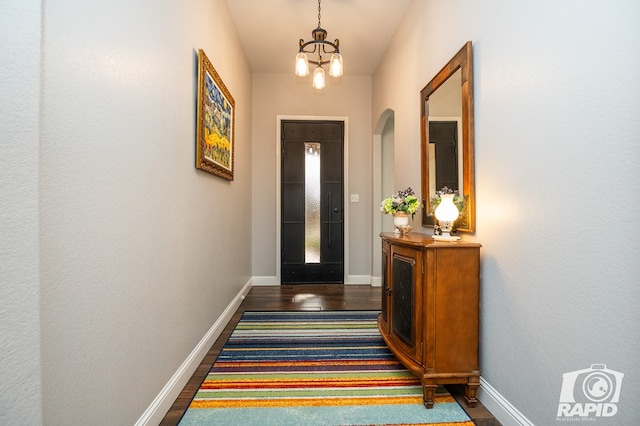 entryway featuring dark hardwood / wood-style floors and an inviting chandelier