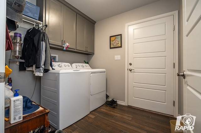 washroom featuring cabinets, washing machine and dryer, and dark hardwood / wood-style flooring