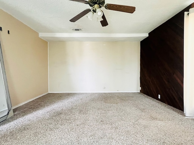 carpeted spare room featuring ceiling fan and a textured ceiling