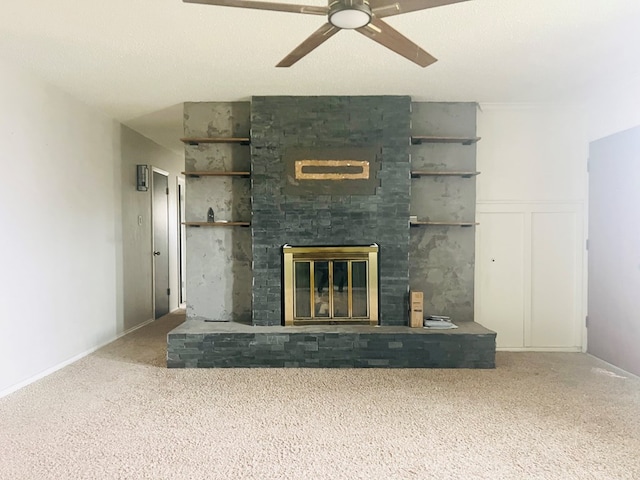 unfurnished living room with carpet, a large fireplace, and ceiling fan