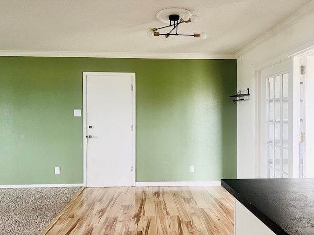 unfurnished dining area featuring crown molding and light hardwood / wood-style flooring