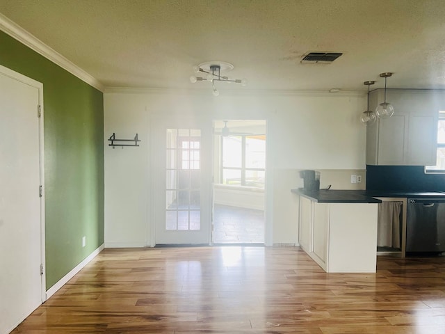 kitchen with pendant lighting, dishwasher, white cabinetry, wood-type flooring, and a textured ceiling