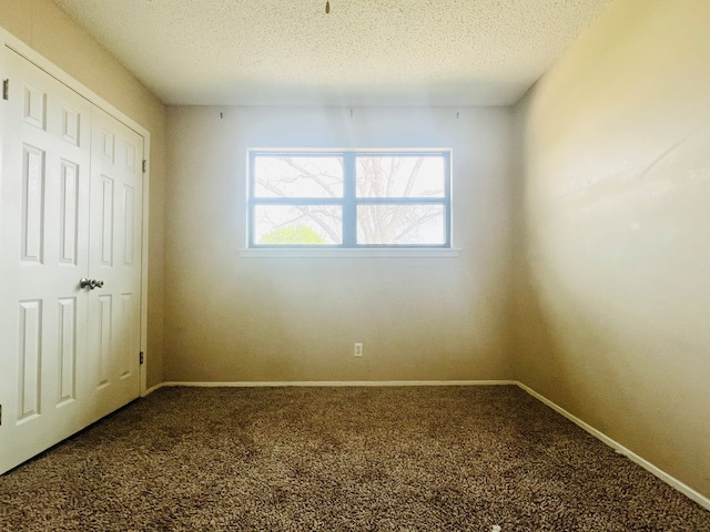 unfurnished bedroom featuring carpet flooring and a textured ceiling