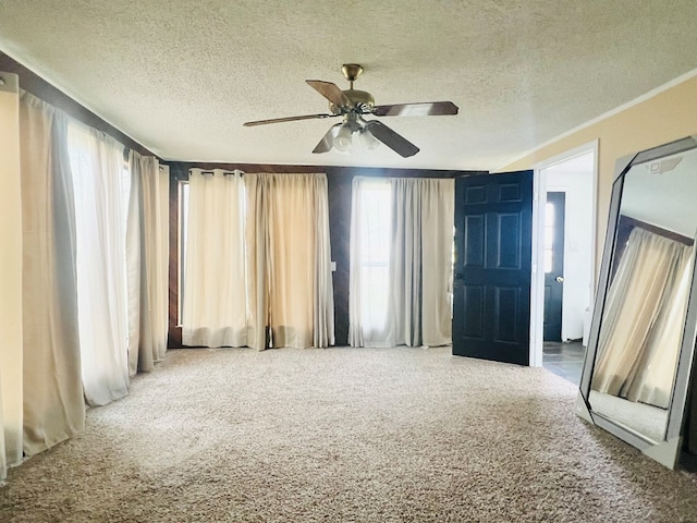 carpeted spare room featuring ceiling fan and a textured ceiling