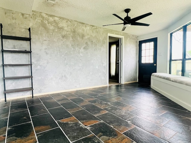 interior space featuring ceiling fan and a textured ceiling