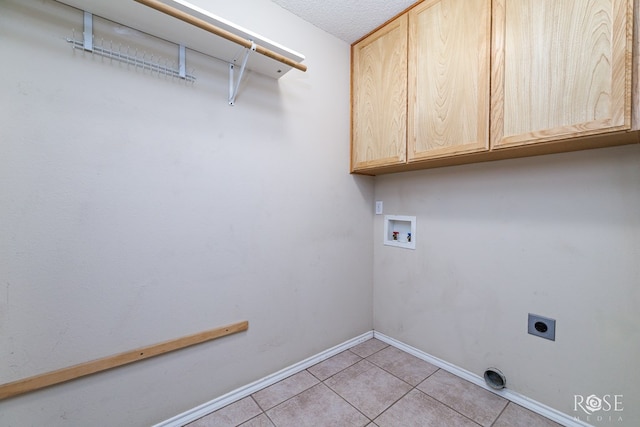 laundry area featuring washer hookup, light tile patterned floors, cabinets, and hookup for an electric dryer