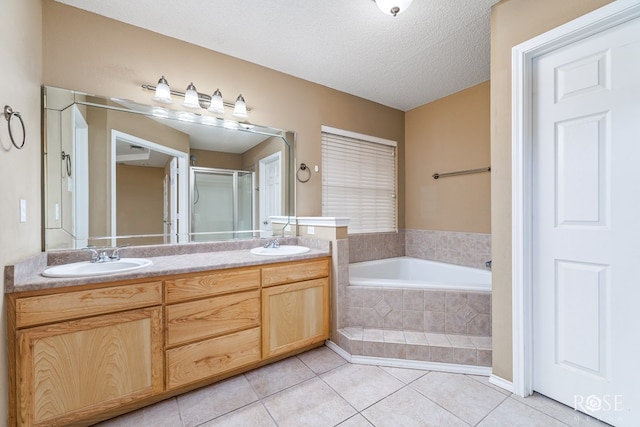 bathroom featuring vanity, shower with separate bathtub, tile patterned flooring, and a textured ceiling