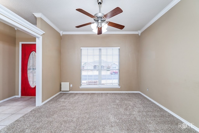 carpeted empty room featuring crown molding, ceiling fan, and a textured ceiling