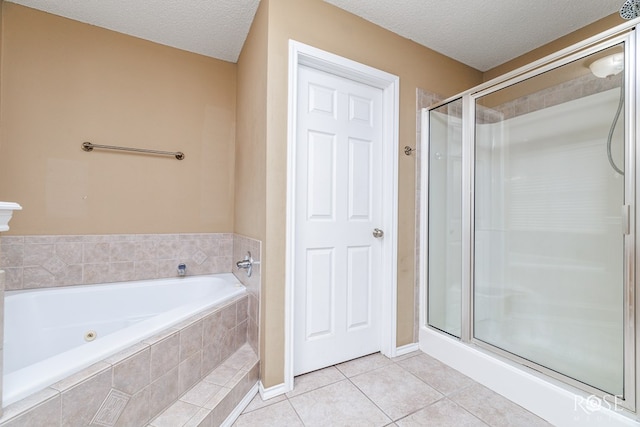 bathroom featuring separate shower and tub, tile patterned floors, and a textured ceiling