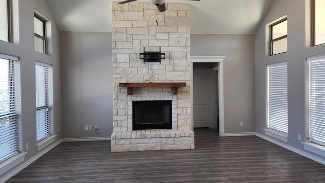 unfurnished living room featuring lofted ceiling, a fireplace, and a wealth of natural light