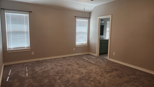 carpeted spare room featuring lofted ceiling