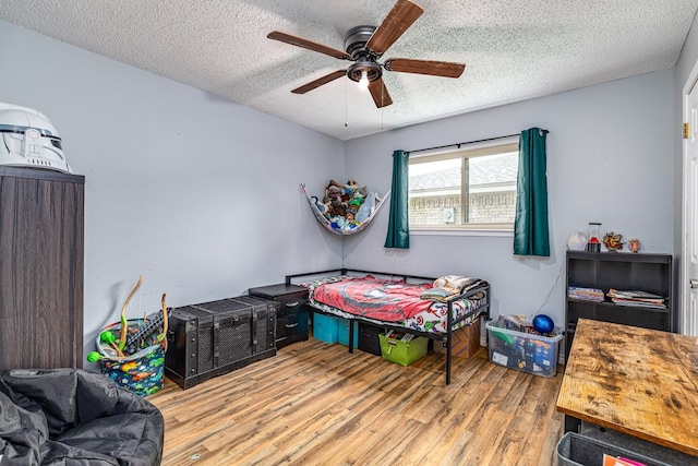 3213 Sunset Dr, San Angelo, TX 76904 - bedroom featuring wood finished floors, a textured ceiling, and ceiling fan