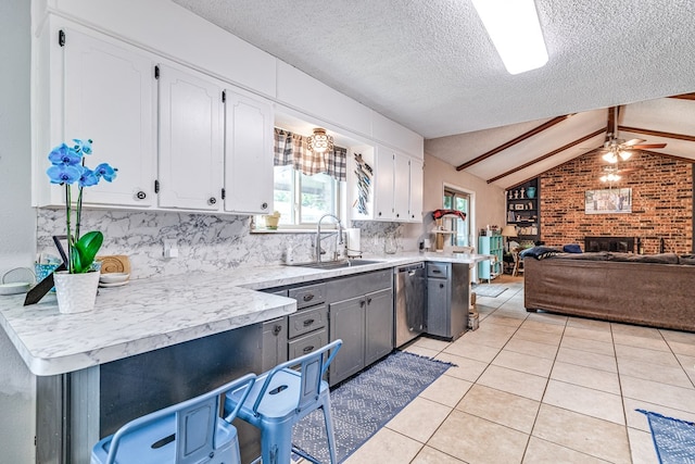 3213 Sunset Dr, San Angelo, TX 76904 - kitchen featuring a sink, stainless steel dishwasher, a ceiling fan, white cabinetry, and a textured ceiling