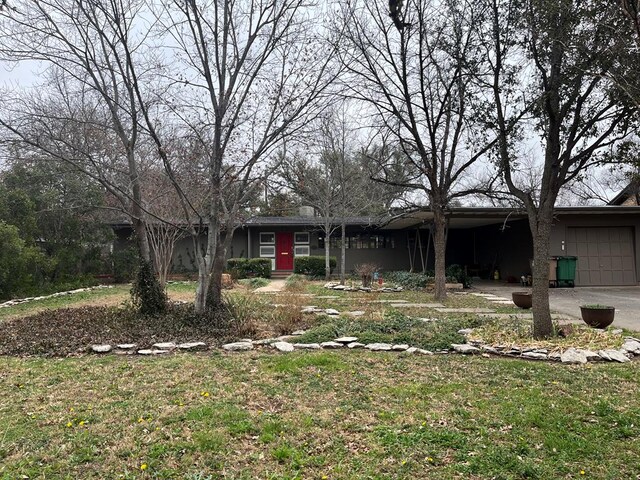 ranch-style house featuring a garage and a front yard