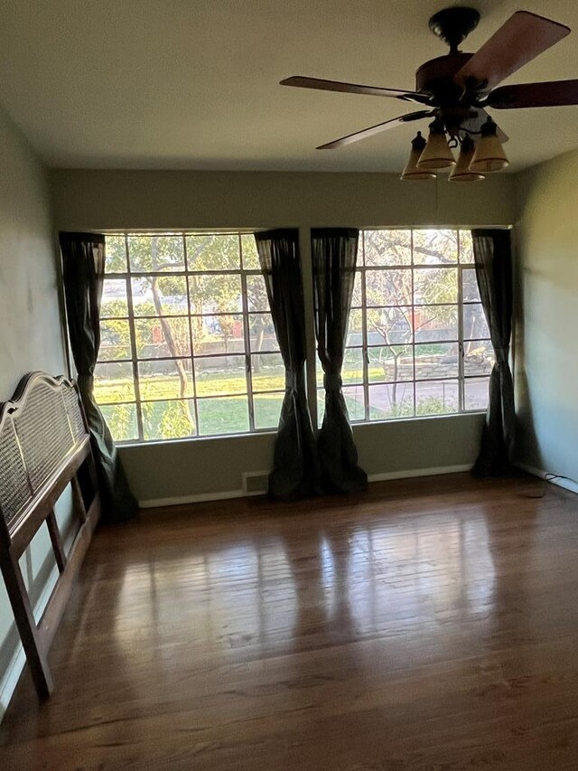 empty room with dark hardwood / wood-style floors and ceiling fan