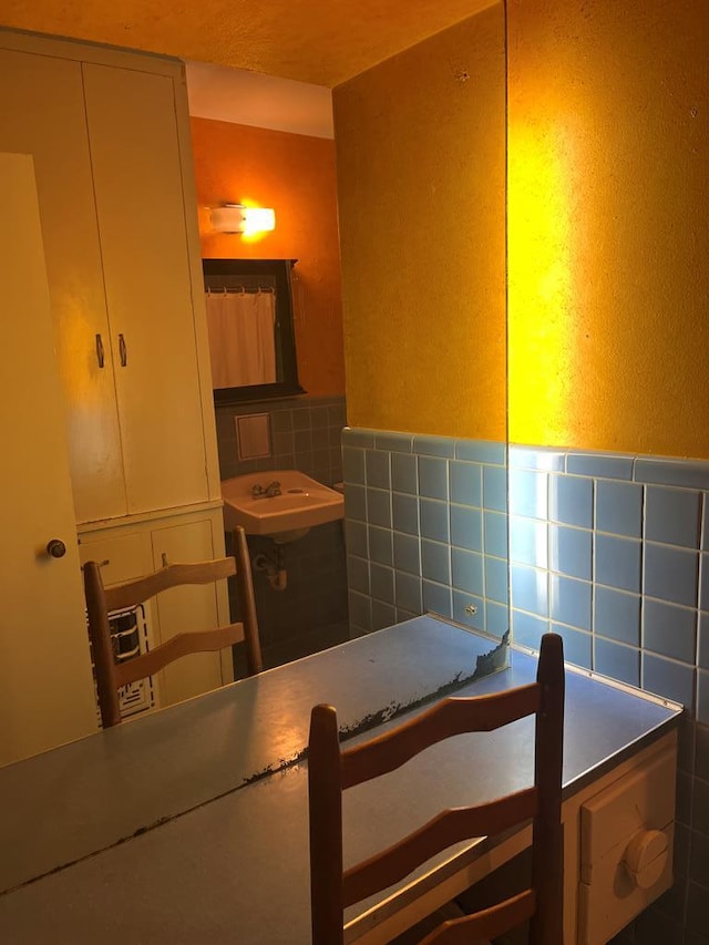 bathroom with sink and tile walls