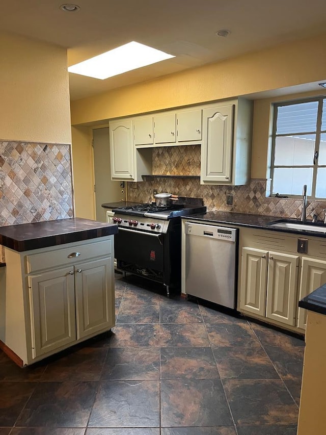 kitchen with stainless steel appliances, sink, backsplash, and a skylight