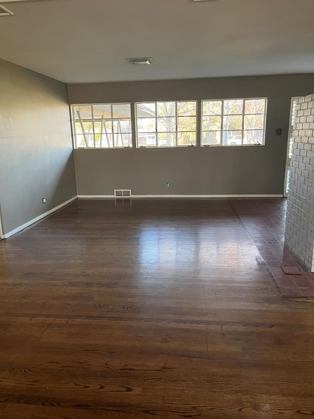 unfurnished room with a wealth of natural light and dark hardwood / wood-style floors