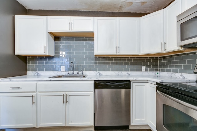 kitchen featuring sink, decorative backsplash, stainless steel appliances, and white cabinets