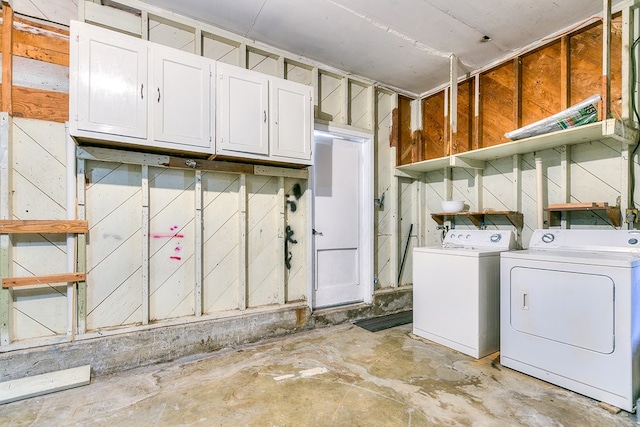 clothes washing area with cabinets and separate washer and dryer