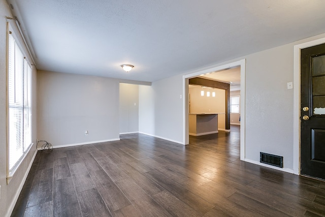 unfurnished room with dark wood-type flooring