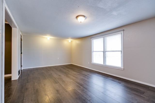 unfurnished room featuring dark hardwood / wood-style flooring and a textured ceiling