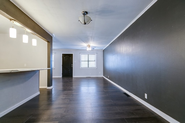 interior space with ceiling fan, ornamental molding, and dark hardwood / wood-style flooring