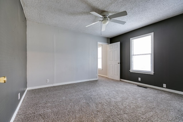 unfurnished room with ceiling fan, carpet floors, and a textured ceiling