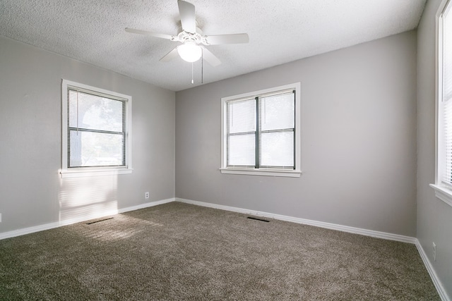 carpeted spare room with ceiling fan and a textured ceiling