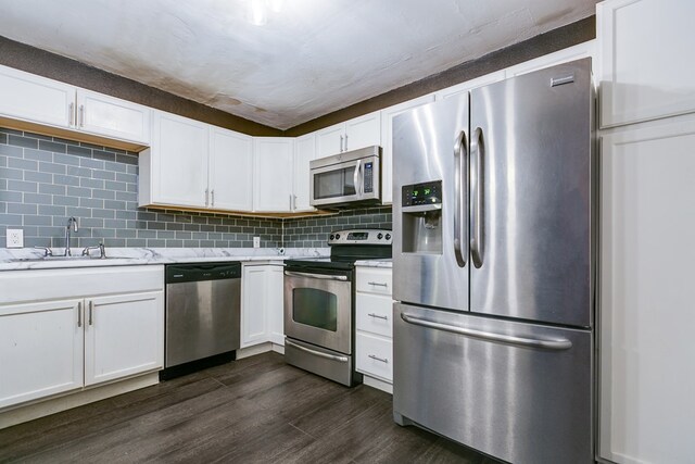 kitchen featuring sink, white cabinetry, stainless steel appliances, tasteful backsplash, and dark hardwood / wood-style flooring